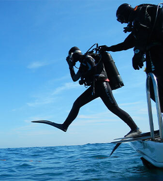 scuba divers jumping into the water from a boat bone island divers